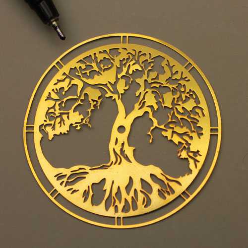 Laser cutting of tree on gold metal with laser cutting machine