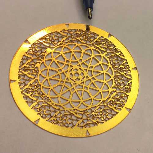 Crucial laser cutting on circular gold metal
